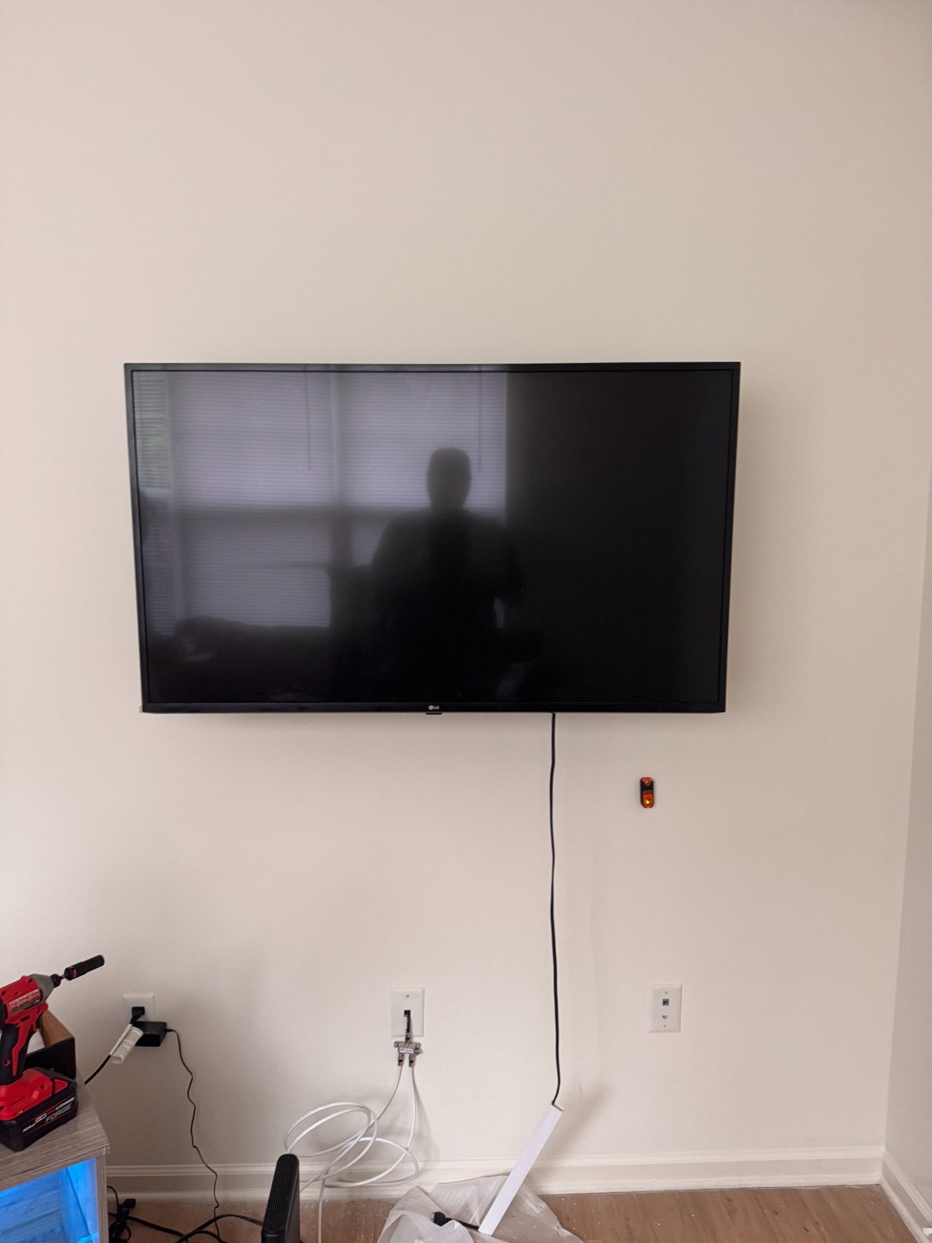 Large television mounted securely on a white wall